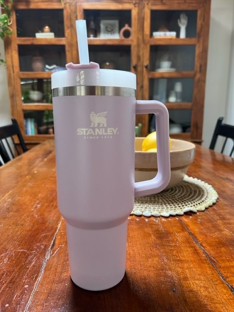 a purple stanley adventure quencher tumbler sitting on a table