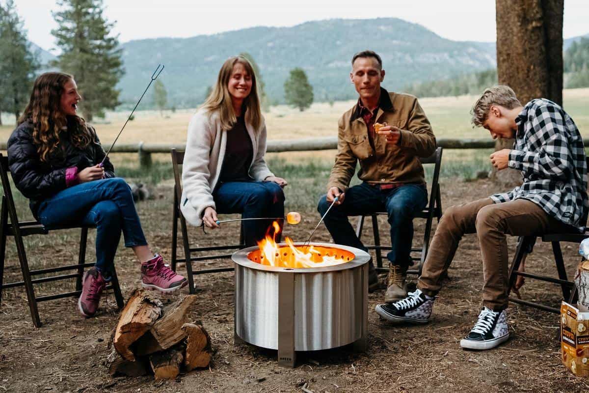 a family sitting around a breeo fire pit