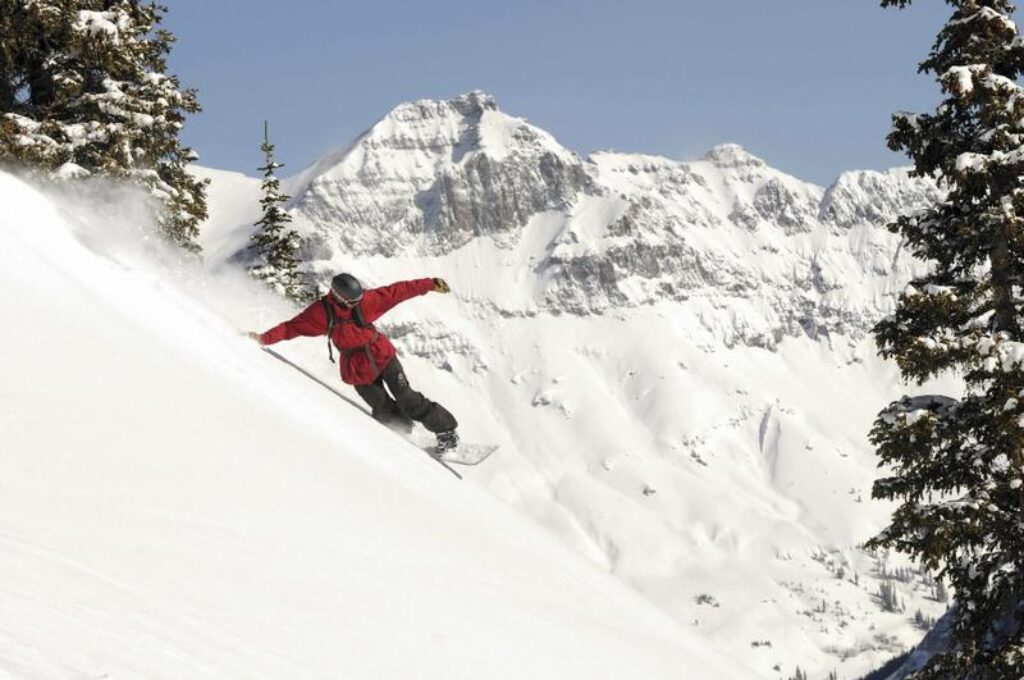 snowboarder turning down a steep slope