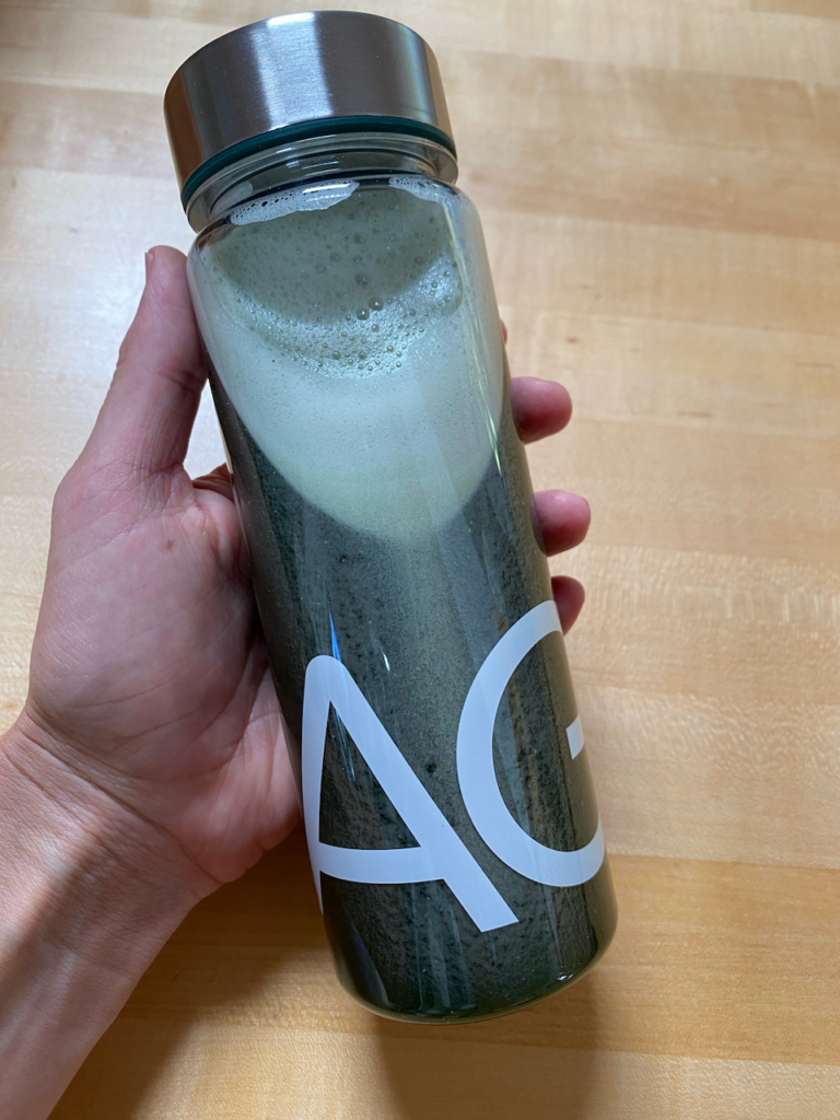 ag1 shaker bottle in a hand